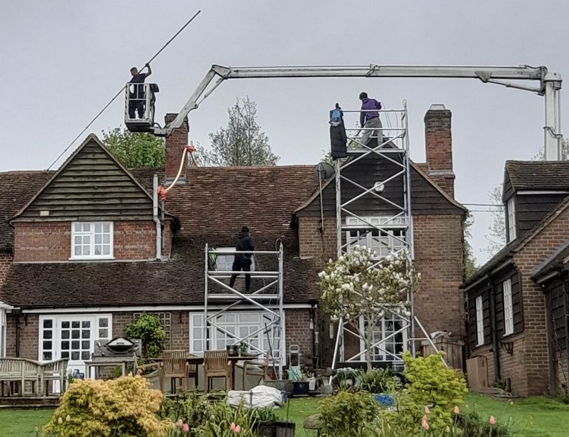 The Moss Cleaners using cherry picker and scaffolding to clean roof safely and professionally in Reigate, Surrey